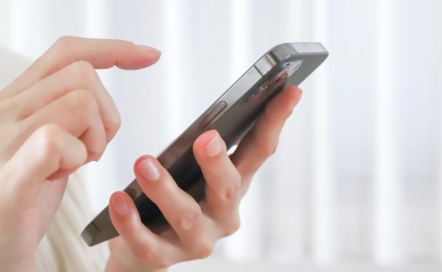 家族葬の八王子市葬儀社に電話でお問合せしようとしている人の手元。